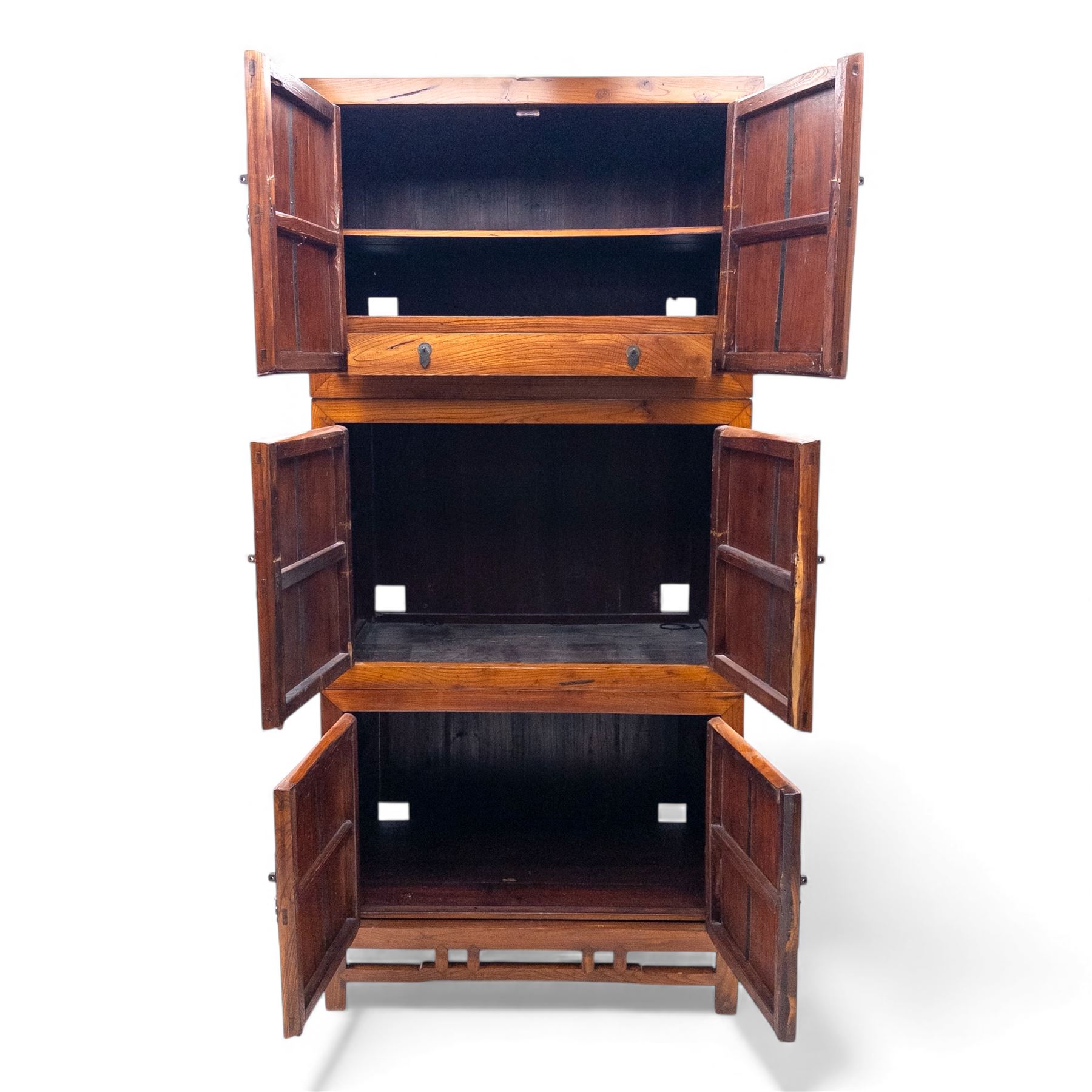 20th century Thai elm compound cabinet, formed of three stacking chests each enclosed by double panelled doors with decorative wrought metal lock plates and hinges, raised on pierced apron on stile feet