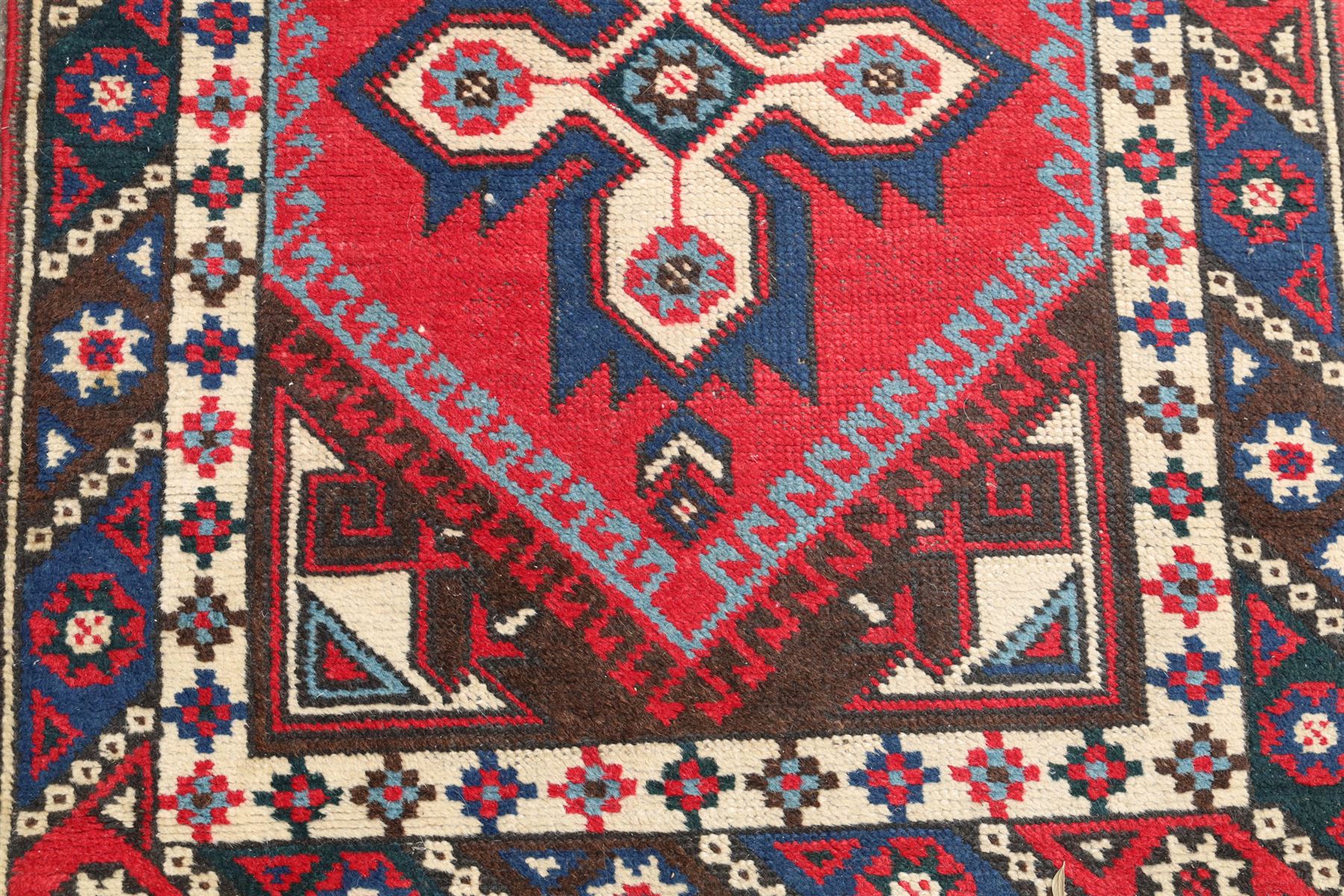 Two Persian rugs, Persian Hamadan hand-knotted rug, ivory ground centred by a terracotta medallion, surrounded by scrolling floral and foliate motifs, dark navy floral border with narrow guard stripes, fringed ends, H 176cm, W 75cm, Persian tribal hand-knotted rug, madder red ground decorated with three large geometric medallions, surrounded by angular motifs, enclosed by multiple geometric borders in dark navy, ivory and red, fringed ends, H 150cm, W 91cm
