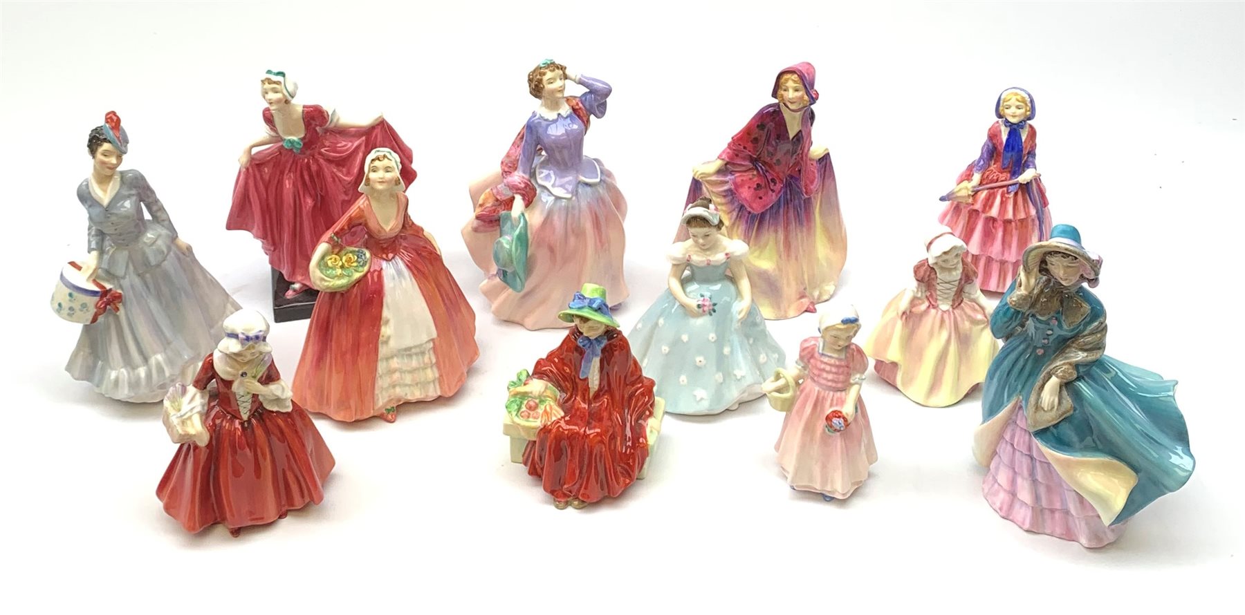 A group of twelve Royal Doulton figurines, comprising Midinette HN2090, Delphine HN2136, Delight HN1772, Sweet Anne HN1496, Blithe Morning HN2021, Janet HN1537, Linda HN2106, Biddy HN1513, Lavina HN1955, Tinkle Bell HN1677, Dinky DO HN2120, and The Bridesmaid HN2196. 