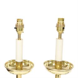Pair of early 20th century brass alter candlesticks converted to table lamps, each with stepped and spreading circular base leading to a double hexagonal knopped column, and plain socket above inverted domed circular drip pan, the socket with light fitting, overall H49cm