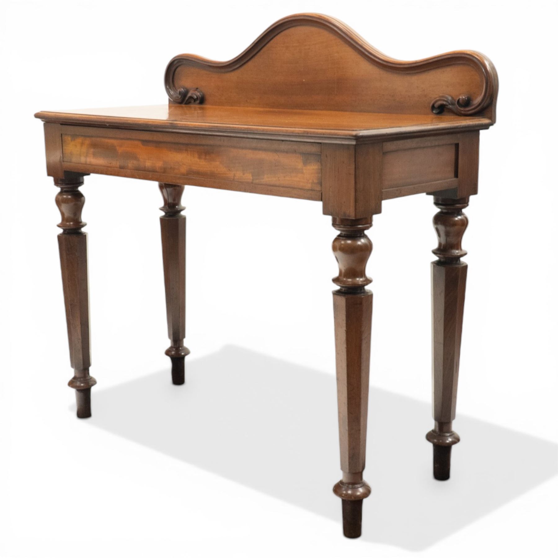 Victorian mahogany side table, raised back with scroll-moulded edge over a rectangular top, raised on turned octagonal supports