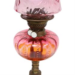 Victorian oil lamp, the brass base supporting cranberry glass reservoir, with clear glass chimney and cranberry shade with fluted rim, overall H59cm