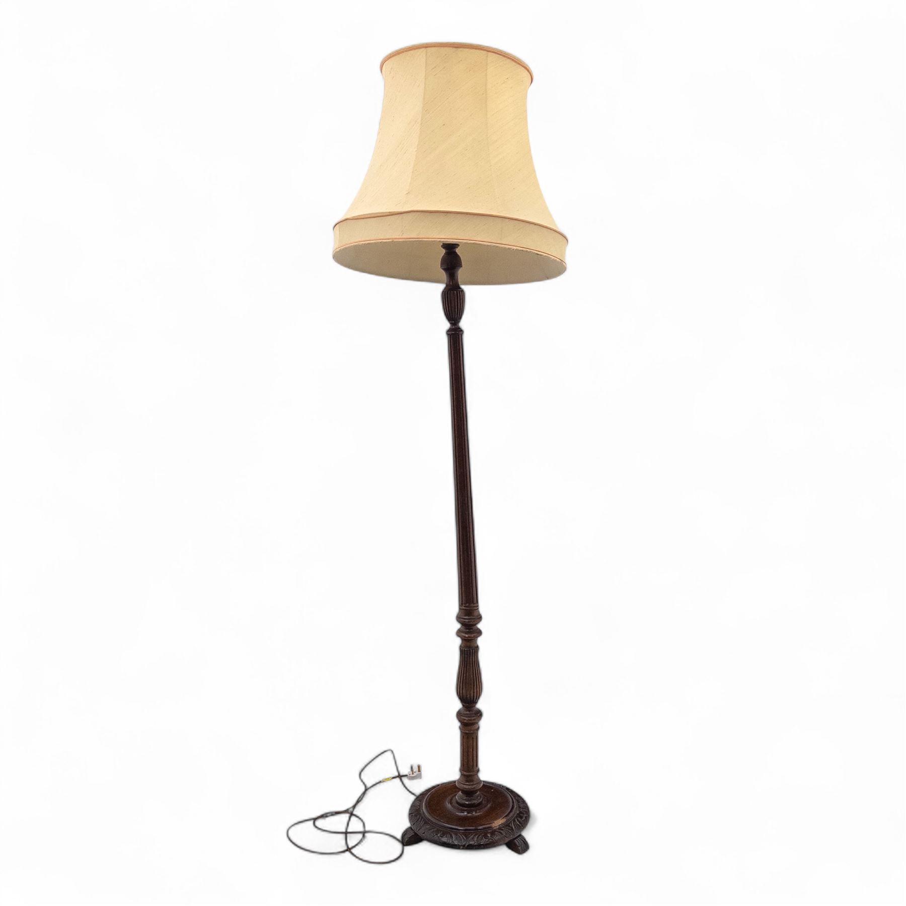 20th century mahogany floor lamp, the reeded column with carved urn knop on circular foliate moulded base, with cream fabric shade