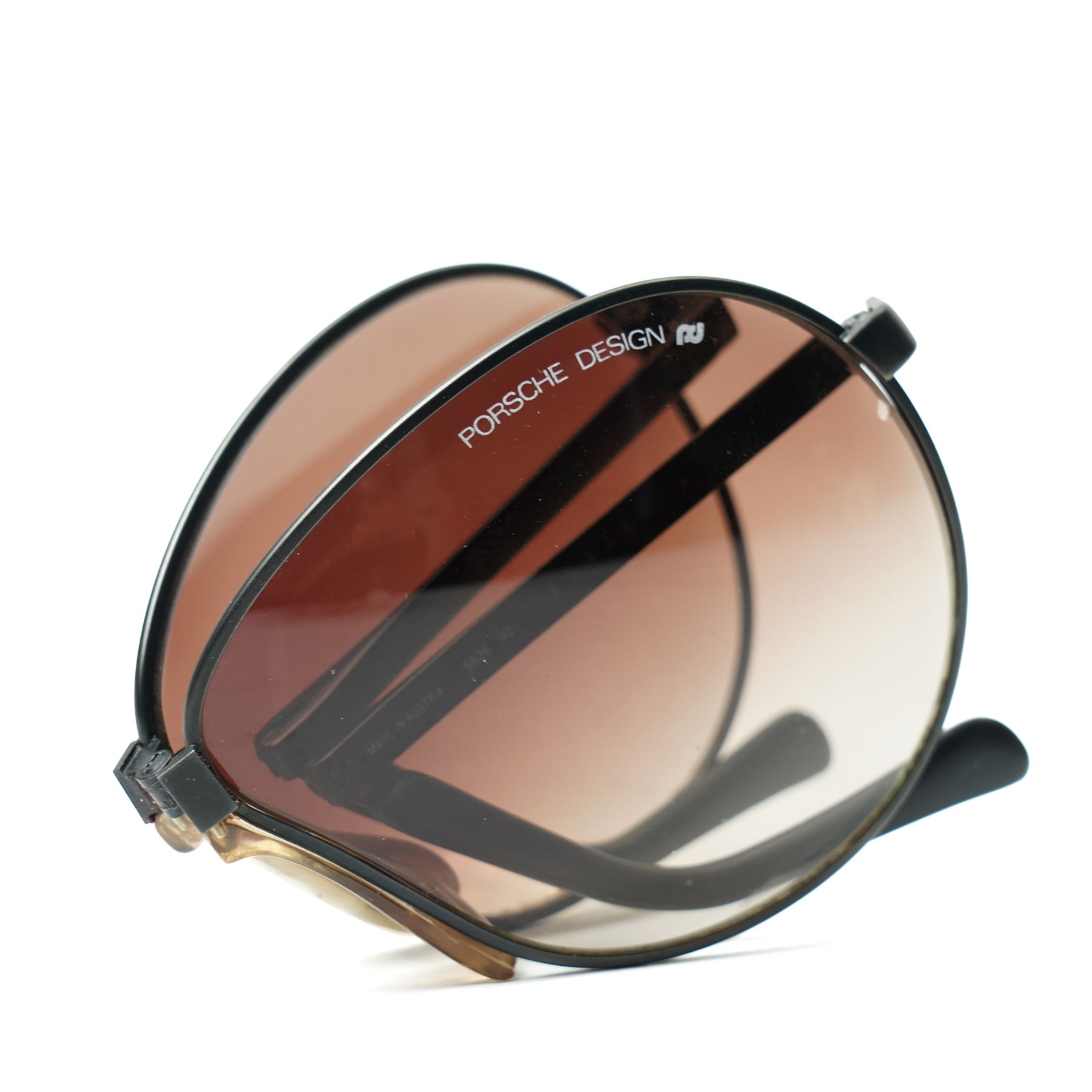 Carrera Porsche Design folding aviator sunglasses, black metal folding frame with brown gradient lenses, double bridge and adjustable nose pads, temples stamped Carrera Porsche Design, together with original Porsche Design case, circa 1980s