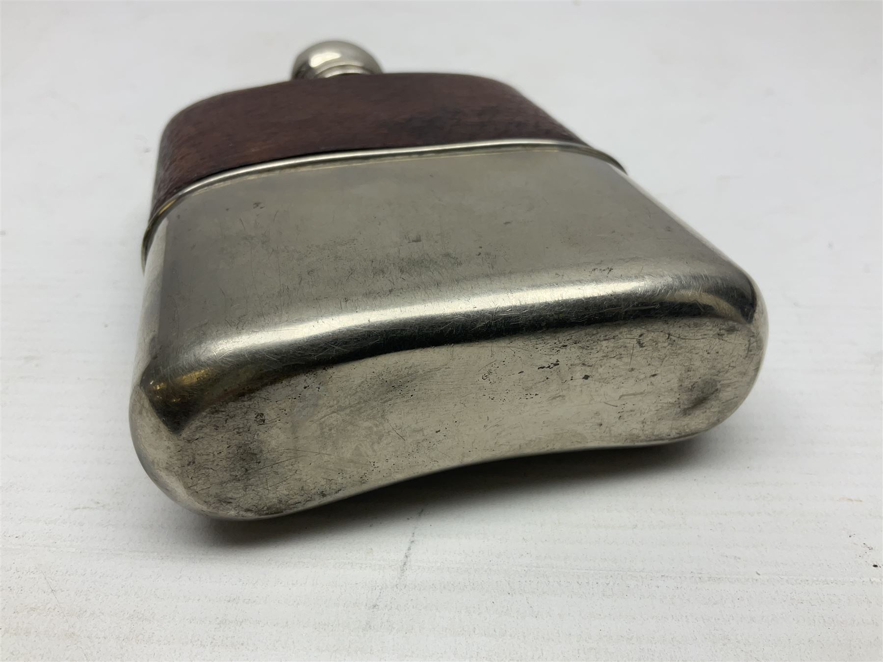 Silver plated glass and pressed leather hip flask, with swivel cap and removable cup, together with a similar oval example, engraved with wreath and initial B, tallest H16.5cm