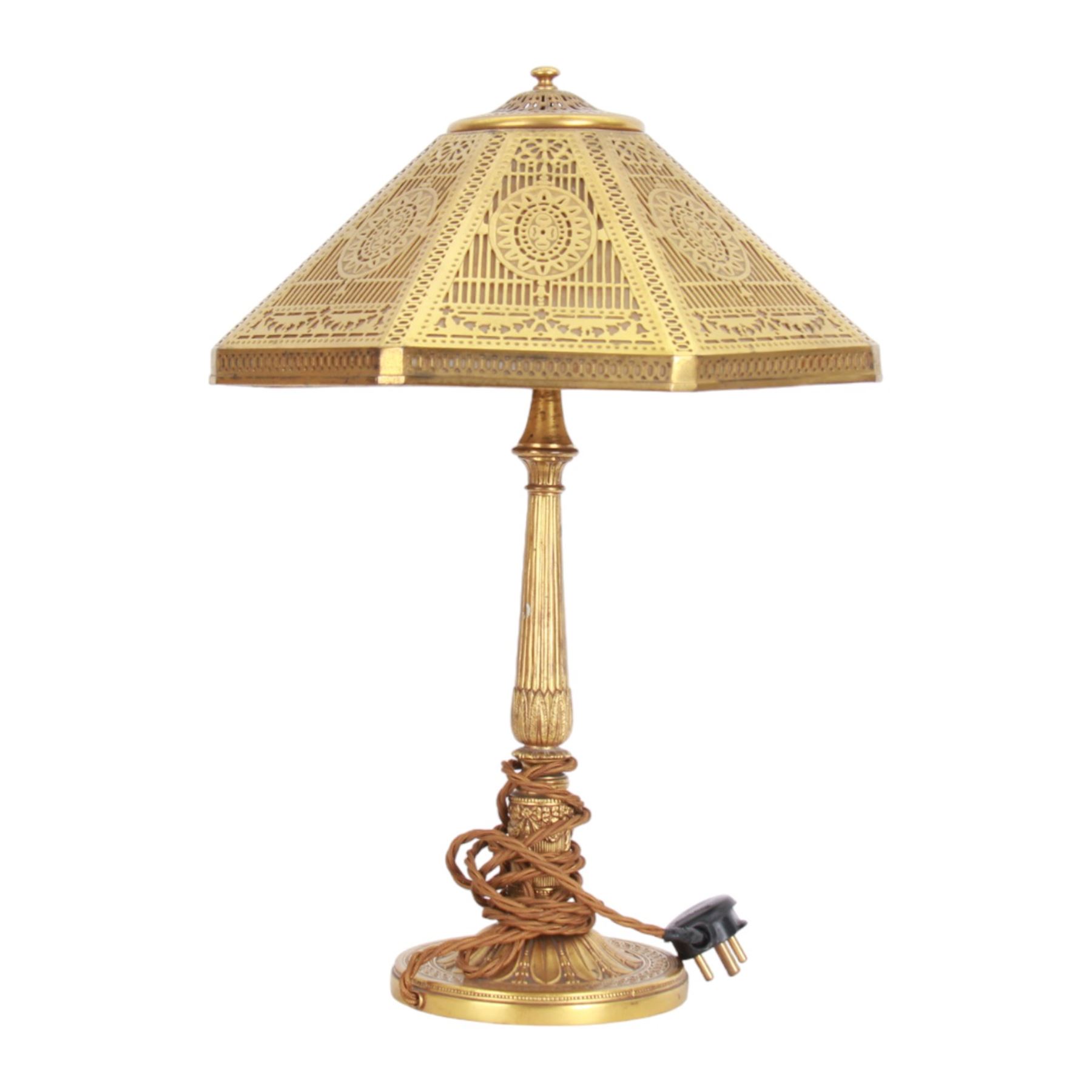 In the manner of Tiffany & Co, early 20th century gilt bronze Adam pattern table lamp, circa 1910, the circular spreading base decorated with flower heads and beaded bands, stiff leaves and husks, leading to a reeded column detailed with stiff leaves and swags, supporting a pierced octagonal shade, with original fittings, stamped beneath Tiffany Studios New York 539, overall H44.5cm


