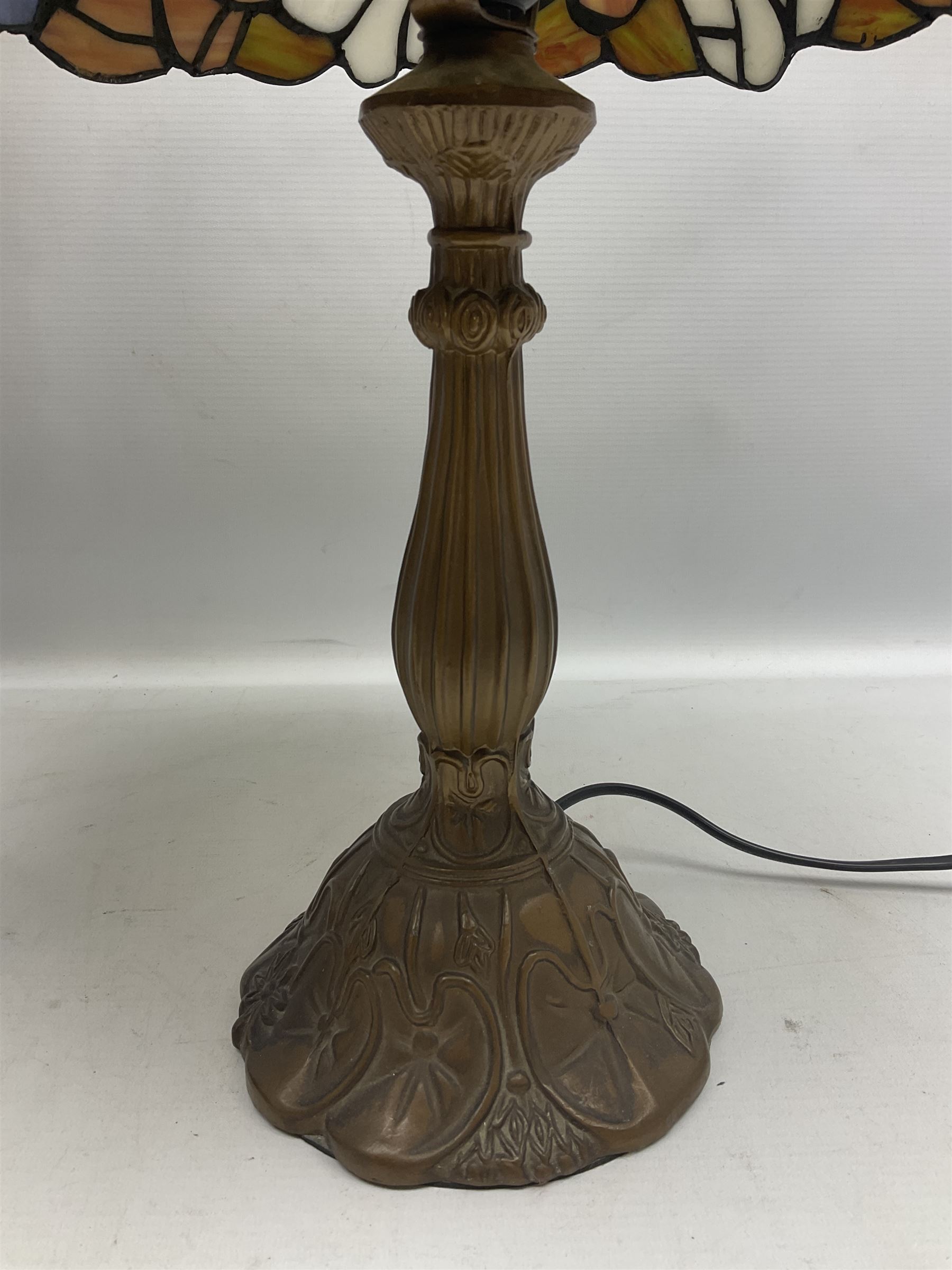 Tiffany style lamp in the form of a semi nude woman holding up a leaded lampshade together with a similar table lamp