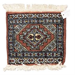 Long flatweave Kilim textile cushion, in crimson and decorated with geometric motifs and cotton fringe ends, 151cm, together with four modern hand-knotted rug mats with geometric designs, the largest 65x43cm, (5)