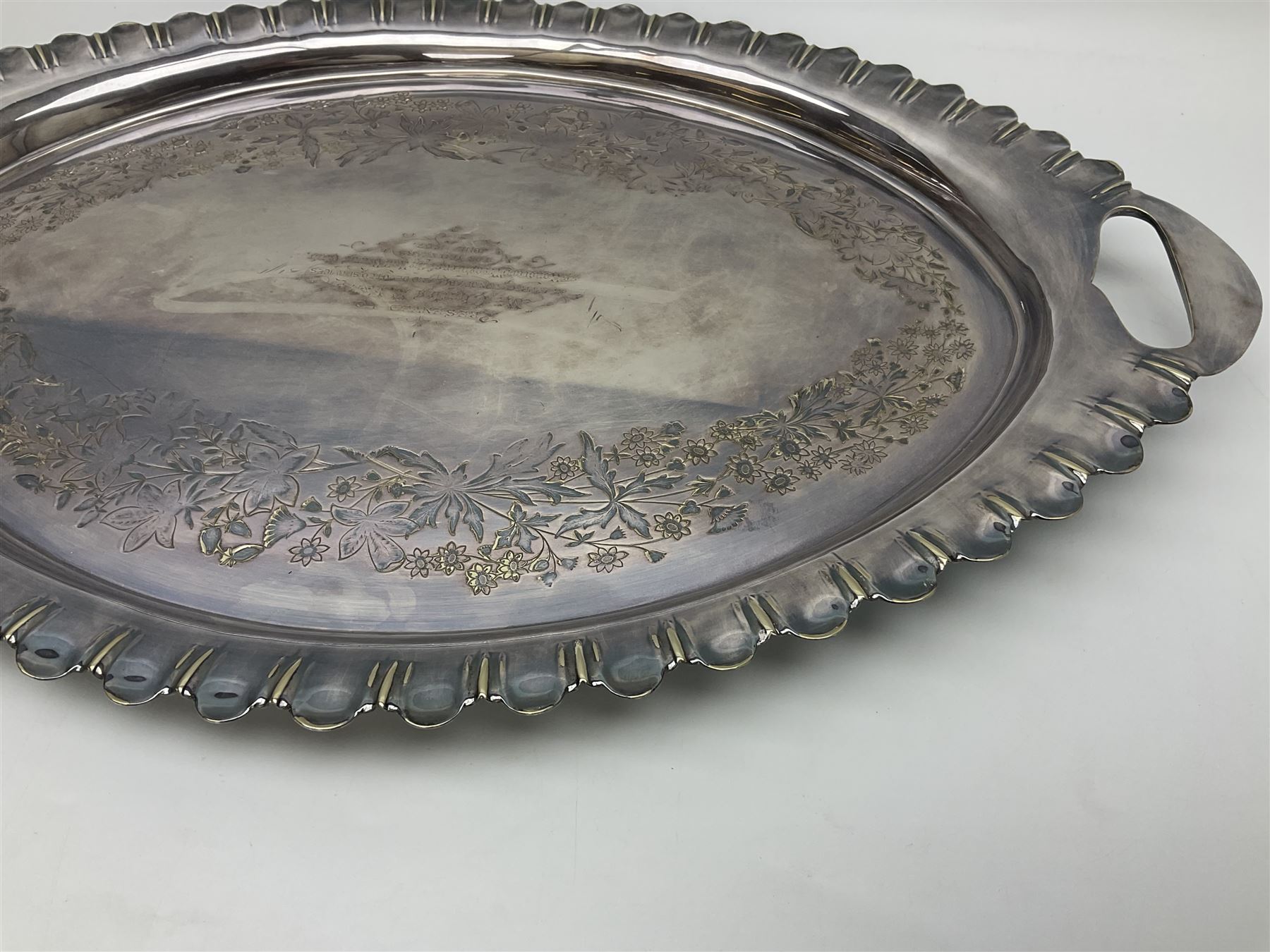 Oval silver plate twin handled tray, egg and dart edge, engraved with floral springs surrounding an central inscription, L65cm