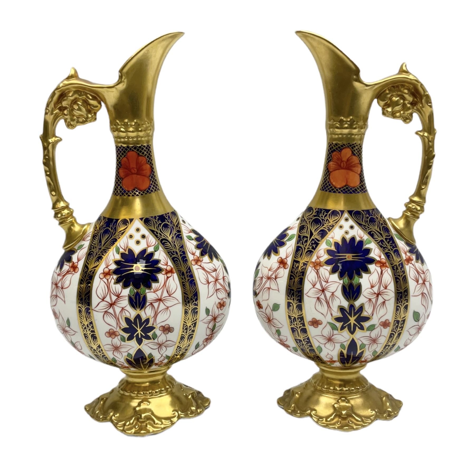 Pair of mid 20th century Royal Crown Derby Imari 1128 pattern Kedleston ewers, each with gilt scroll handle and neck, upon a gilt quatrefoil foot, each with printed marks beneath, H25.5cm