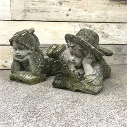  Pair composite stone figures of a boy and girl in prone position reading, H34cm, L50cm  