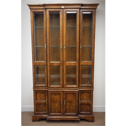  Quality walnut veneered breakfront display cabinet, with four bevel glazed and four panel doors on a skirted base, W114cm, H202cm, D43cm  