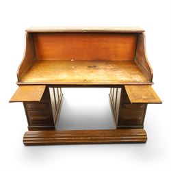 Cutler - Late Victorian oak pedestal tambour desk, the tambour shutter enclosing fitted interior, pull-out writing surface over central kneehole flanked by two pedestals each fitted with four drawers with moulded fronts, pull-out slides above, panelled sides, on moulded plinth base