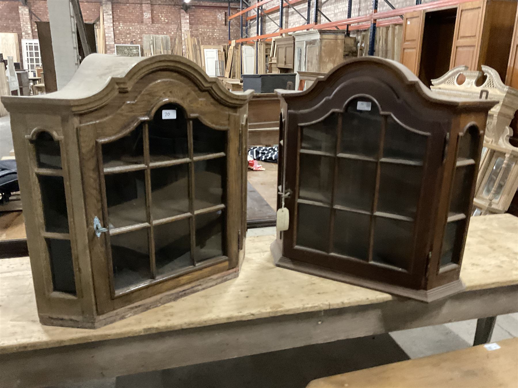 Dutch design oak wall hanging apothecary cabinet, of arched form with single astragal style glazed door enclosing single shelf (W69cm D18cm H69cm); together with another similar of corner form (W75cm D48cm H69cm) - THIS LOT IS TO BE COLLECTED BY APPOINTMENT FROM THE OLD BUFFER DEPOT, MELBOURNE PLACE, SOWERBY, THIRSK, YO7 1QY