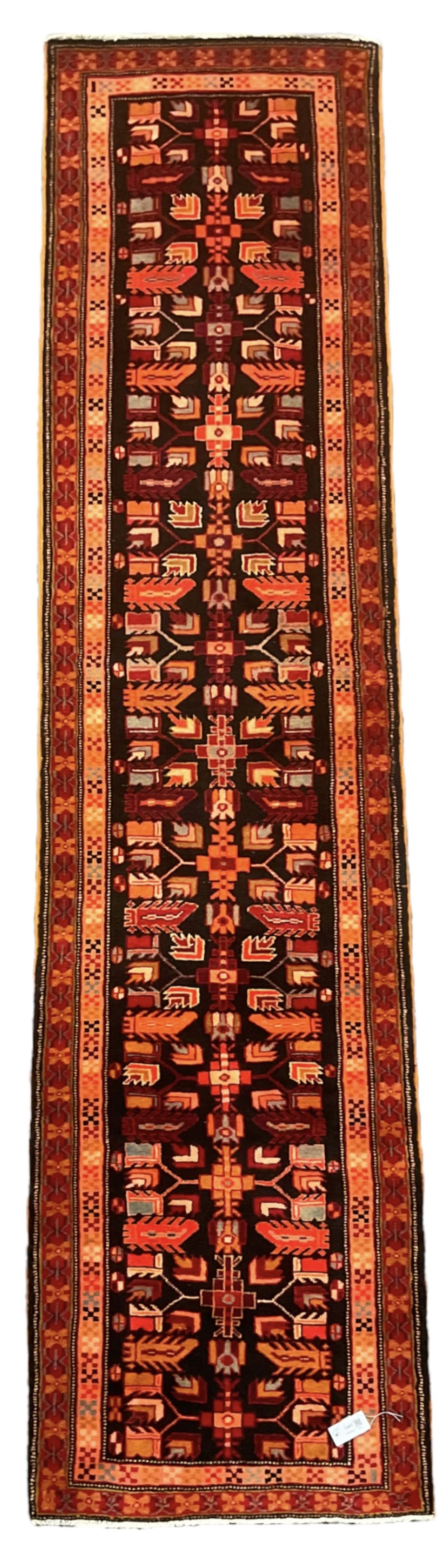 North West Persian Heriz runner, dark indigo ground field decorated with Herati motifs, peach and red borders with geometric design 