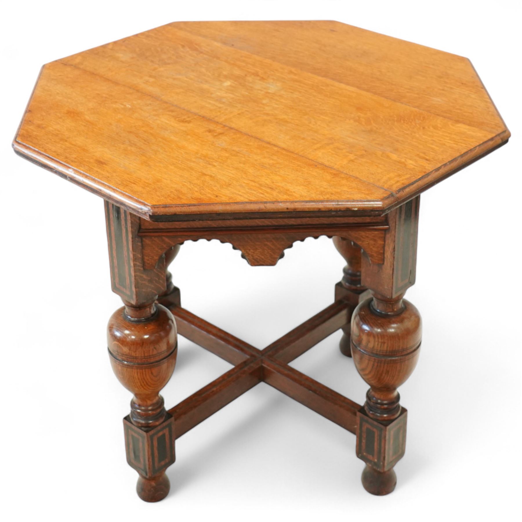 Late Victorian oak centre table, octagonal moulded top over a carved Gothic arched frieze, raised on quadruple baluster turned supports united by X-stretcher with ebonised detailing