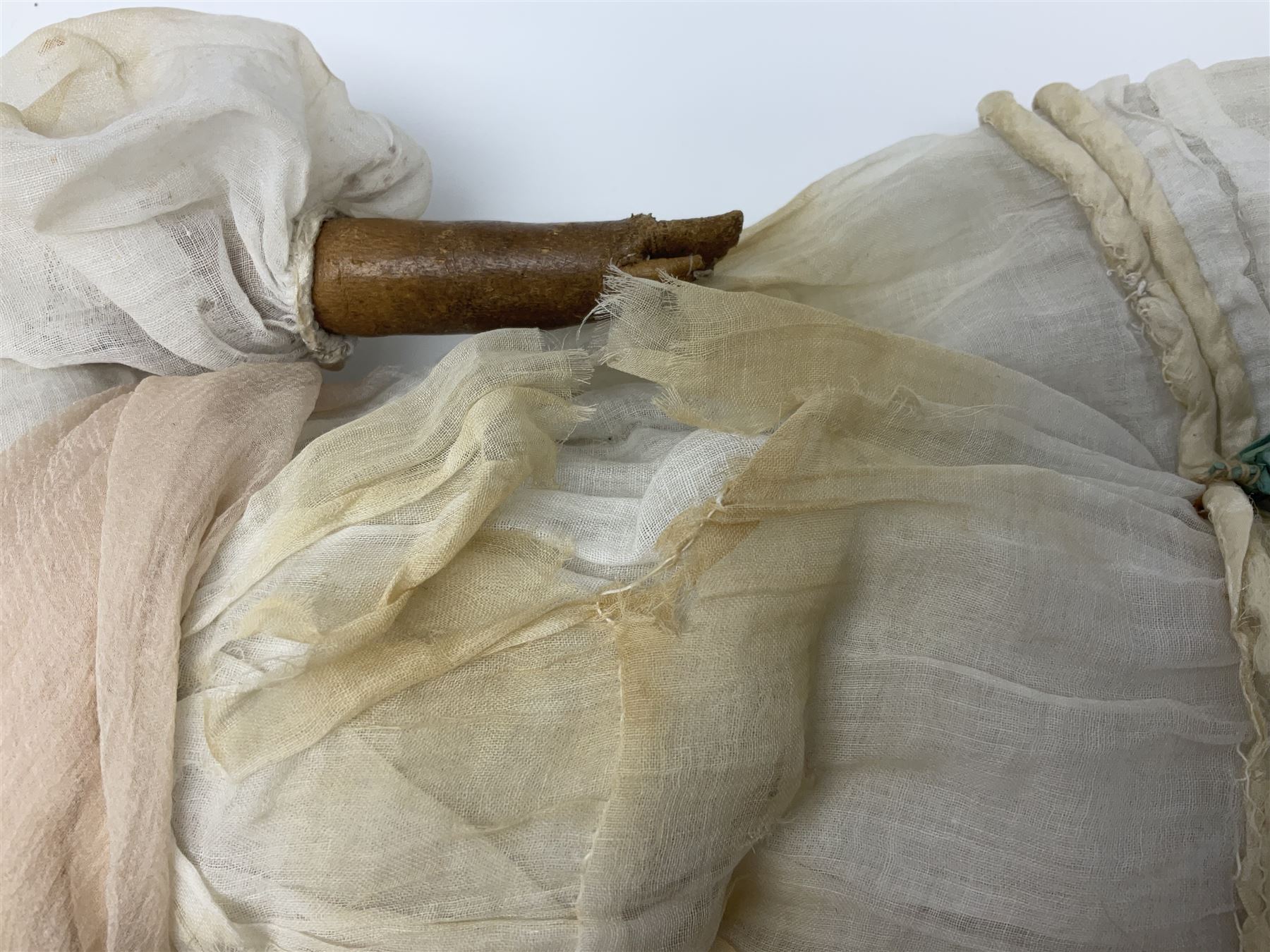 Victorian wax shoulder head doll with pale complexion, applied hair, inset glass eyes and fabric covered jointed body with kid leather lower arms; white linen dress and undergarments H50cm