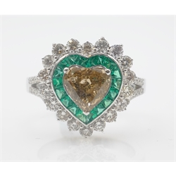 White gold heart shaped ring set with central champagne diamond surrounded by calibre cut emeralds and round brilliant diamonds, champagne diamond approx 1.2 carat, tested to 18ct
