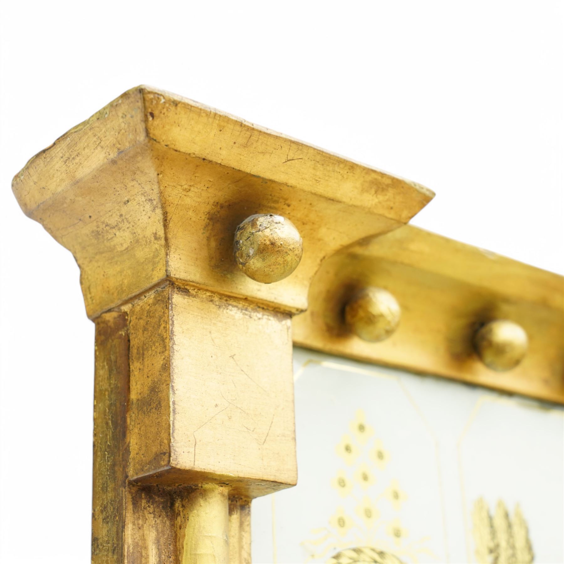 Regency giltwood pier mirror, projecting moulded cornice with ball mounts, the glazed frieze decorated with coastal ship and castle scene and flanked by to floral baskets, ebonised reeded slip enclosing bevelled mirror plate