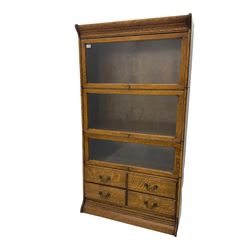 Early 20th century Globe Wernicke style oak library bookcase, three sections enclosed by hinged and sliding glazed doors, the lower section fitted with four small drawers