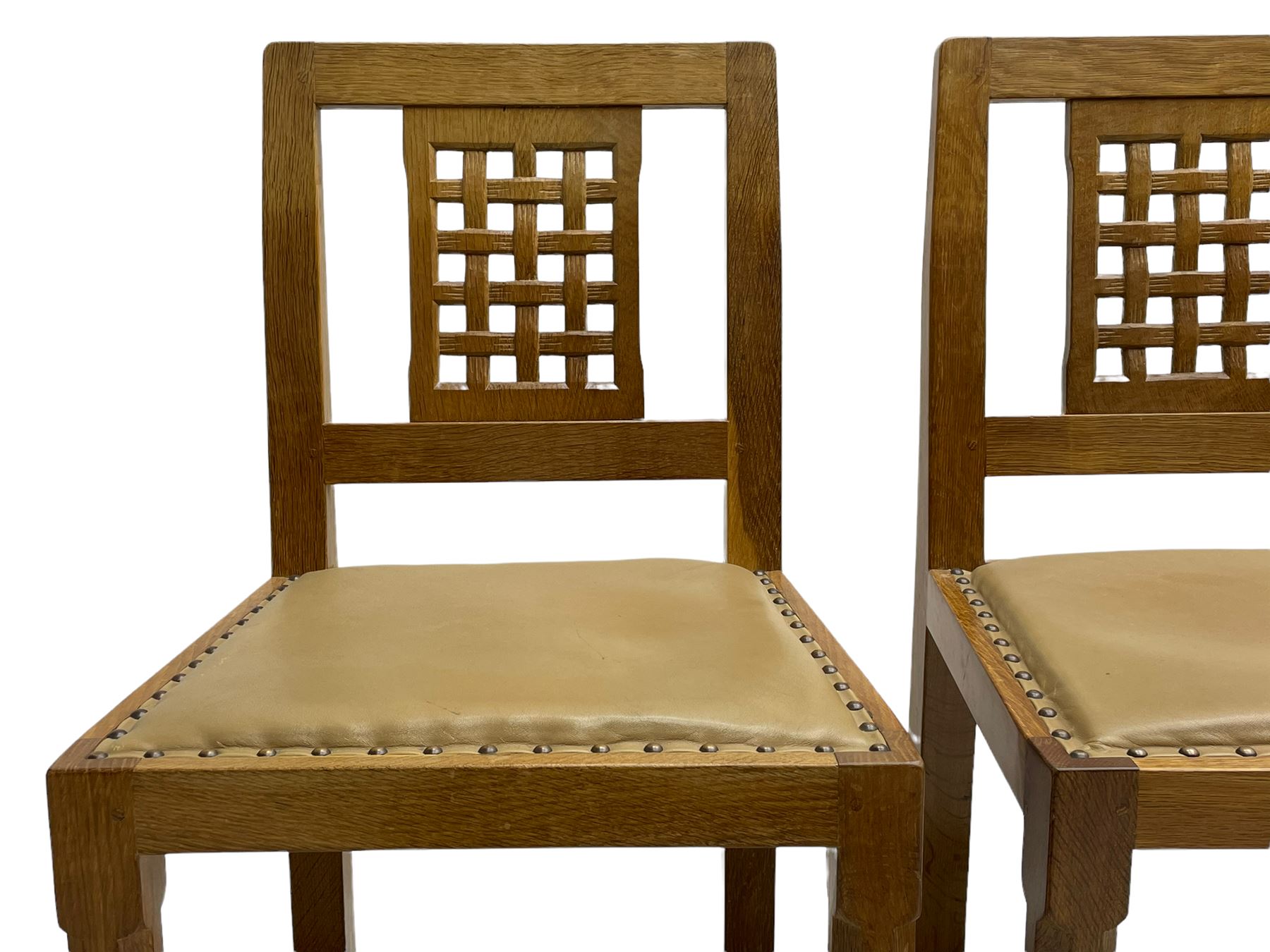 'Rabbitman' set of eight oak dining chairs, pierced lattice backs, upholstered seats with studwork band, octagonal front supports joined by stretchers, carved with rabbit signature, two carvers and six side chairs, by Peter Heap of Wetwang
