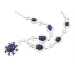 18ct white gold sapphire and diamond milgrain set necklace, oval cabochon cut sapphire surrounded by eight round brilliant cut diamonds and eight French cut sapphires, suspending from a diamond set leaf pendant, single round brilliant cut diamond and a larger old cut diamond, the chain set with six graduating cabochon cut sapphires, each surrounded by diamonds and spaced by a single diamond and a diamond set leaf, to a belcher link chain necklace, hallmarked, total sapphire weight approx 27.00 carat, total diamond weight approx 7.50 carat