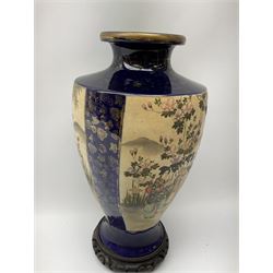 An early 20th Century Japanese vase, of baluster form decorated with panels of figures in a garden setting, upon deep blue ground, with character mark beneath, H37cm. 