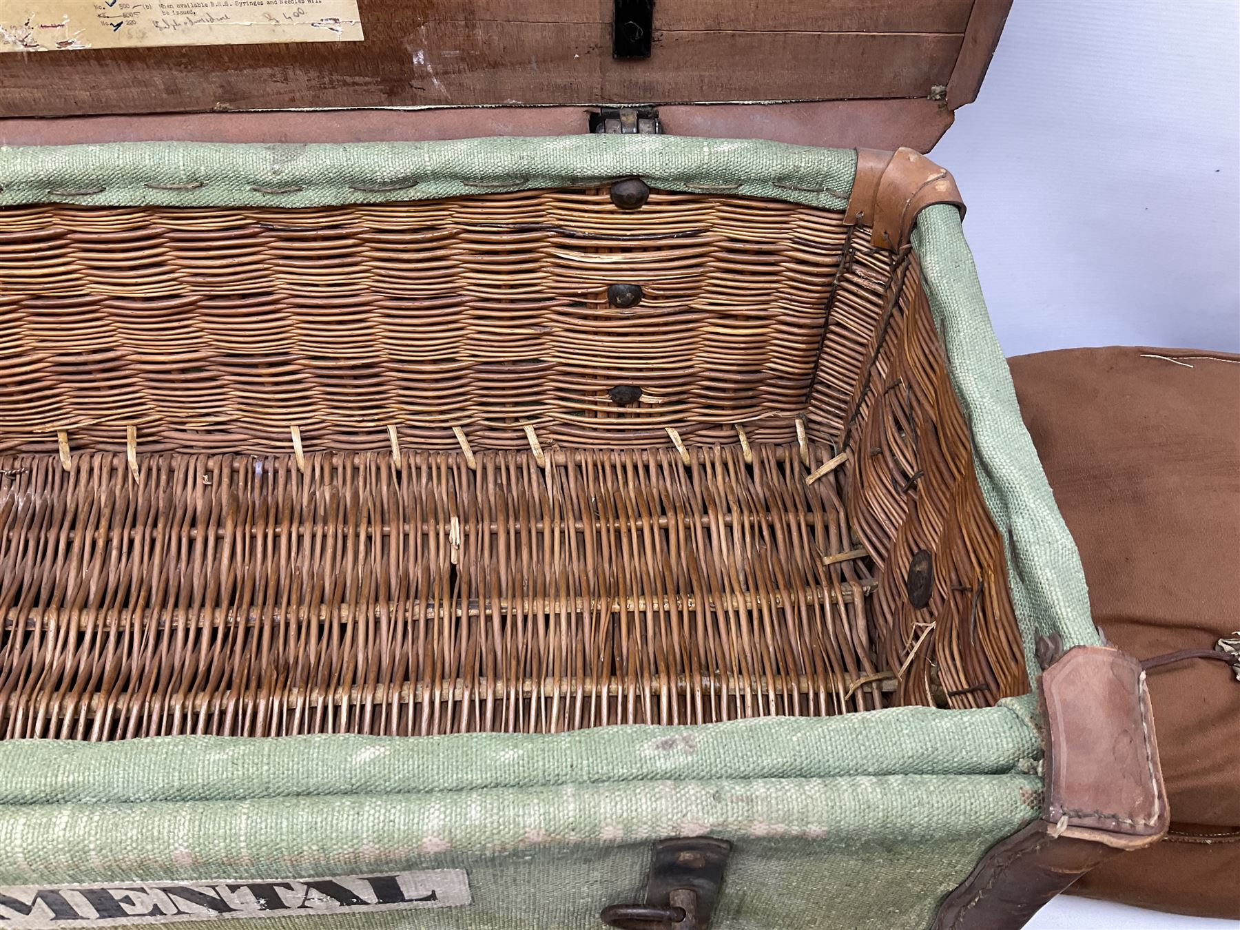WW2 British Army RAMC 'Regimental Medical Pannier', well marked externally and dated 1941, stamped May 1943 internally, canvas covered wicker form with leather edges, hinged top and fall front with two rope carrying handles, fitted iron locking straps with securing chains; contains various unused field dressings and bandages with WW2 dates and two pillows; original label under lid L79cm