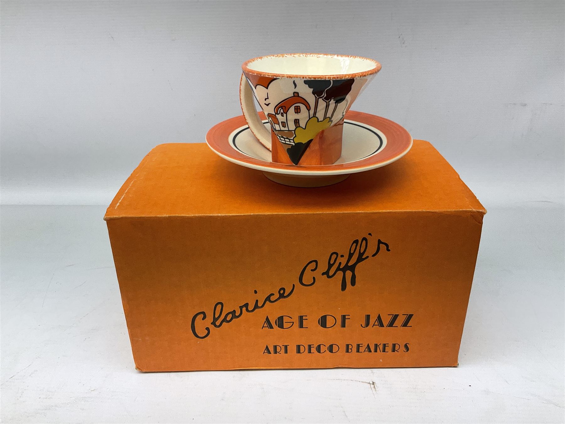 Two limited edition Bradford Exhange Clarice Cliff Age of Jazz beakers, no 289/4,999, with certificate, in box, together with a Moorland Art Deco Clarice Cliff style Huntley Cottage pattern teacup and saucer 
