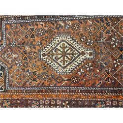 Baluchi red and amber ground rug, field decorated with central geometric lozenge surrounded by stylised plant motifs, guarded border with repeating plant and flower head designs