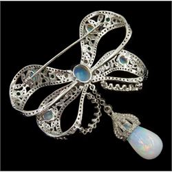 Silver opal, emerald and diamond bow brooch, suspending a pear cut opal and diamond pendant drop, total opal weight approx 4.50 carat, total diamond weight approx 3.95 carat