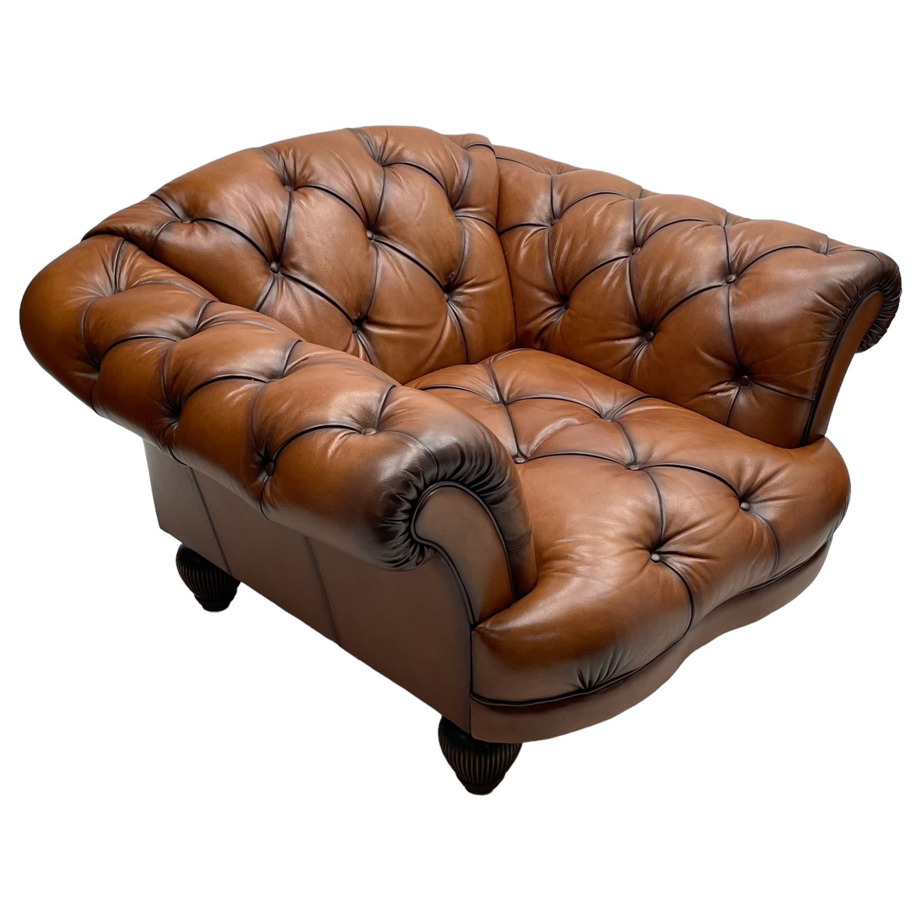 Tetrad - 'Oskar' armchair, Chesterfield shape with rolled arms, upholstered in buttoned tan leather, on turned and reed moulded feet 
