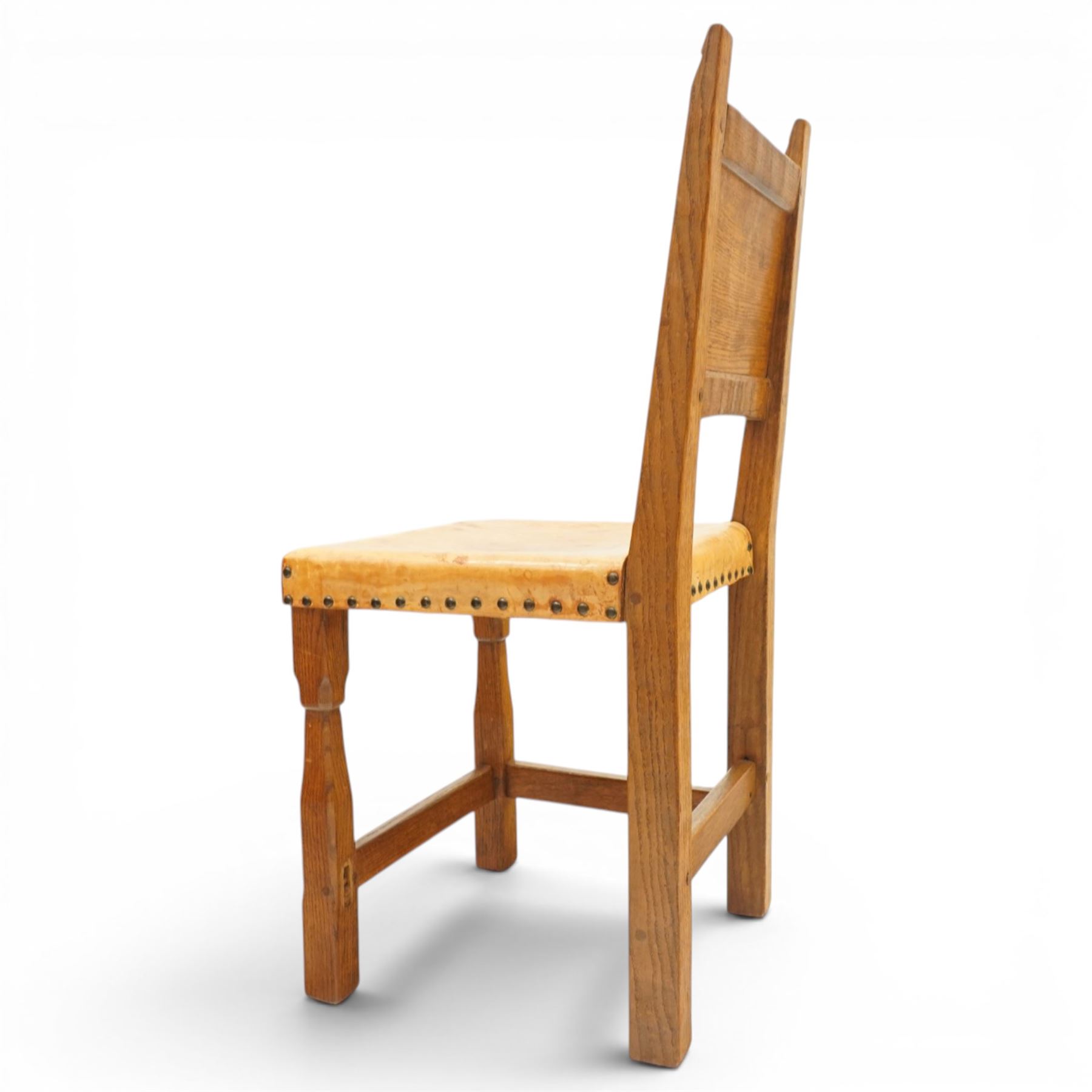 Gnomeman - set of six oak dining chairs, the adzed panelled backs with chamfered rails, over seats upholstered in tan leather, raised on chamfered and tapering square supports united by box stretchers, carved with gnome signature, by Thomas Whittaker, Littlebeck, Whitby