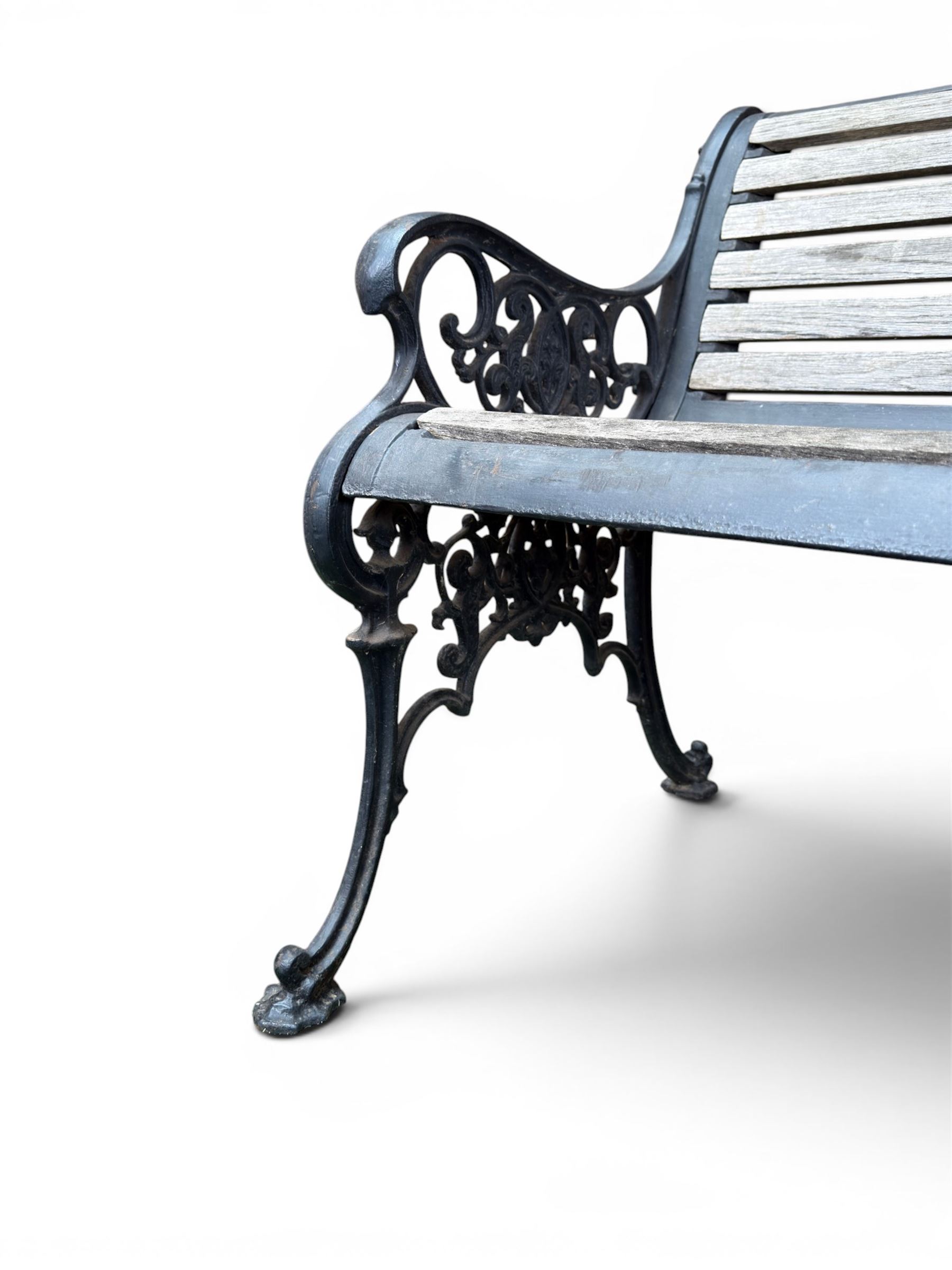 Victorian Andrew McLaren pattern cast iron bench, the ornate ends with detailed scrollwork, joined together with a cast iron seat and backrest frame supporting gently weathered oak slats, Victorian diamond stamp mark