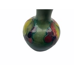 Moorcroft vase, decorated in the Leaf and Berries pattern upon a tonal green ground, together with a further Moorcroft vase, of squat baluster form, decorated in the Iris pattern upon a tonal green ground, each with impressed marks beneath, each H9cm. 