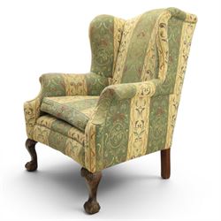 Queen Anne style wingback armchair, upholstered in green and cream foliate fabric, shaped arms on ball and claw feet