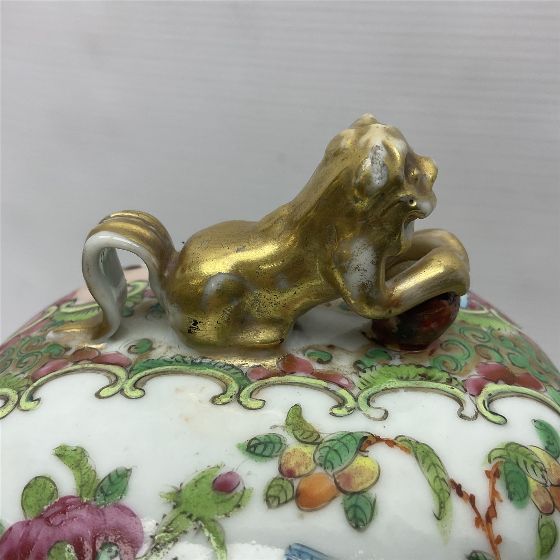 Pair of 19th century Chinese Famille Rose vases and covers, each of baluster form with twin gilt lion mask ring handles to shoulders, the flattened domed covers with gilt temple lion finials, each decorated with alternating reserves of bijin and attendants, and birds and butterflies amongst blossoming peonies, against a gilt ground profusely decorated with stylised scrolls, H32.5cm