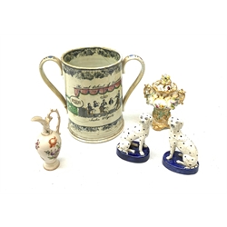 A large 19th century Staffordshire loving cup, detailed 'The Real Cabinet of Friendship Justice and Equity' (a/f), H22cm, together with a pair of 19th century Staffordshire dalmatians, upon oval blue bases, H13cm, a Dresden ewer hand painted with floral sprays, with mark beneath, H15.5cm, and a Coalbrookdale style floral encrusted vase and cover, H16.5cm. 