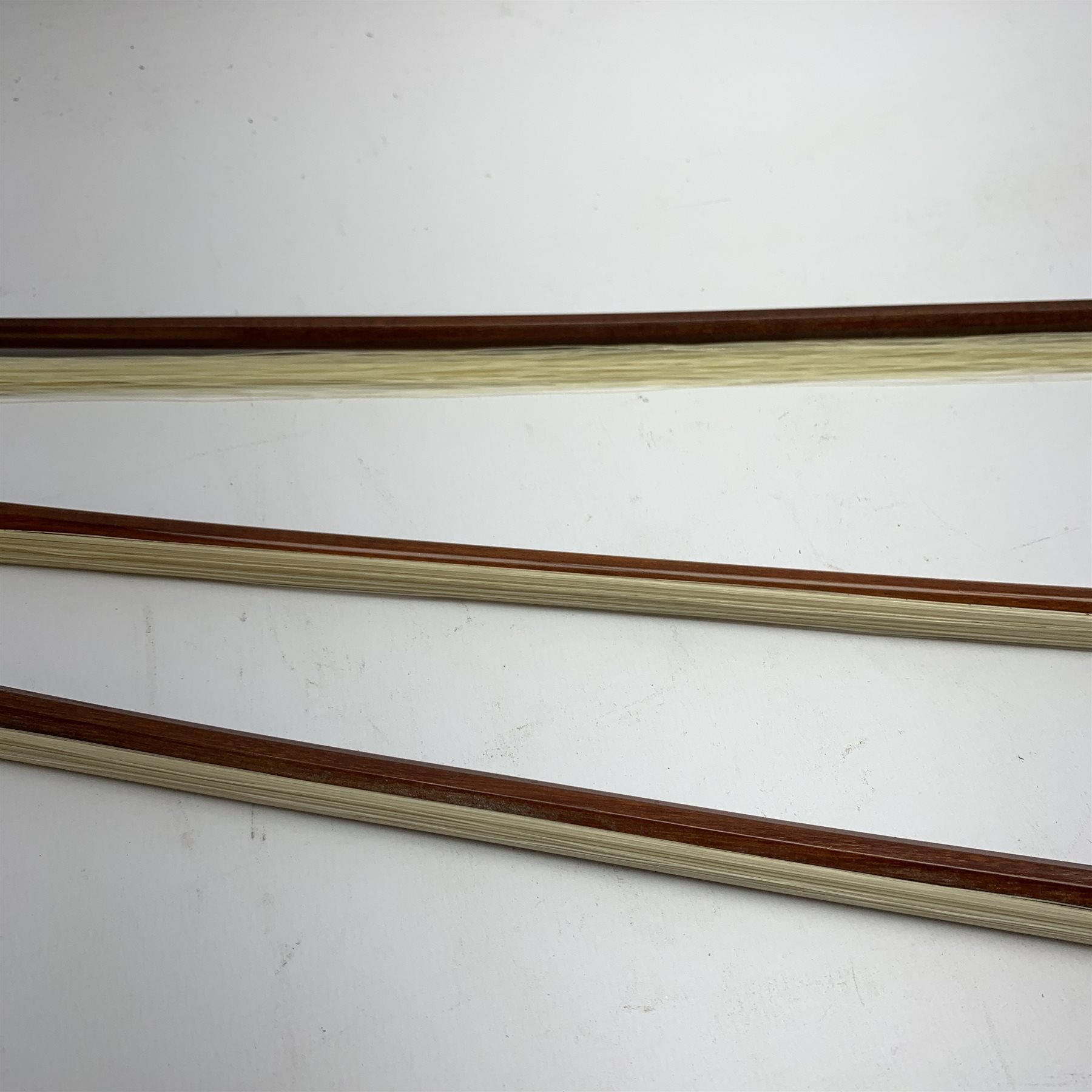 Three pernambuco bows by F.C. Pfretzschner with silver mounts, Adolf Thoma and Tourte