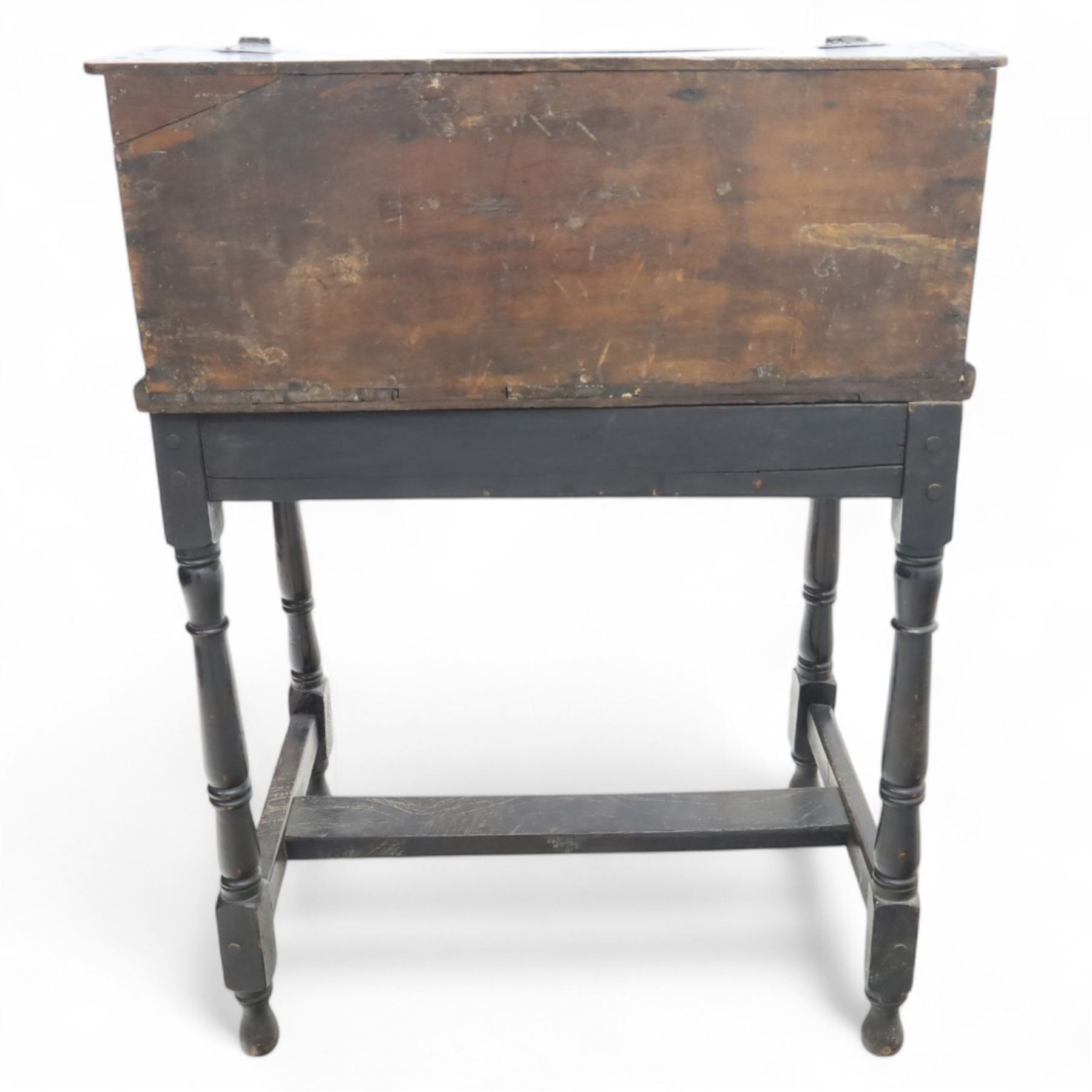 18th century carved oak Bible box on stand, the sloping lid with incised initials ‘MD’ and iron strap hinges, the front carved with stylised leaf and scroll panels enclosing central iron lockplate, on stand with gadrooned frieze, turned legs and plain stretchers