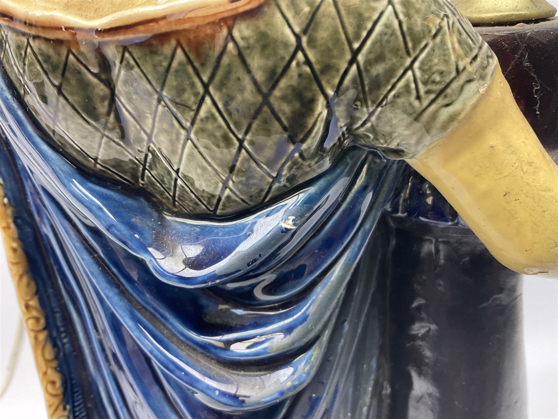 Composite table lamp modelled as a Roman Emperor donning blue robes, upon quatrefoil base modelled with rams heads and winged cherubs, H56cm excl fitting