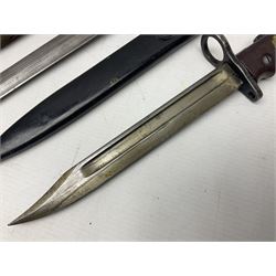 British No 7 MKI knife bayonet with 20cm single edged fullered clipped point blade;  blackened steel, large muzzle ring cross-guard; blackened swivelling pommel marked 'F5H'; red Tufnol composite grips; in blackened steel scabbard L33cm overall; British Pattern 1888 bayonet with scabbard; and German Ersatz bayonet with scabbard (3)