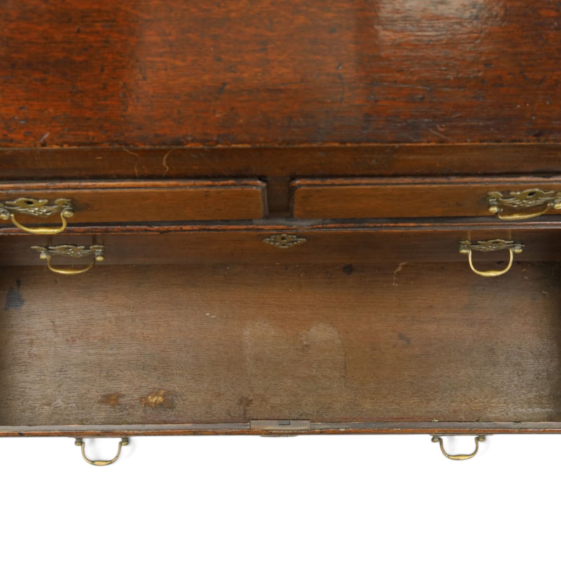Georgian oak bureau, fall front with pierced brass escutcheon and handles, revealing a fitted interior, above two short over two long drawers, raised on bracket feet