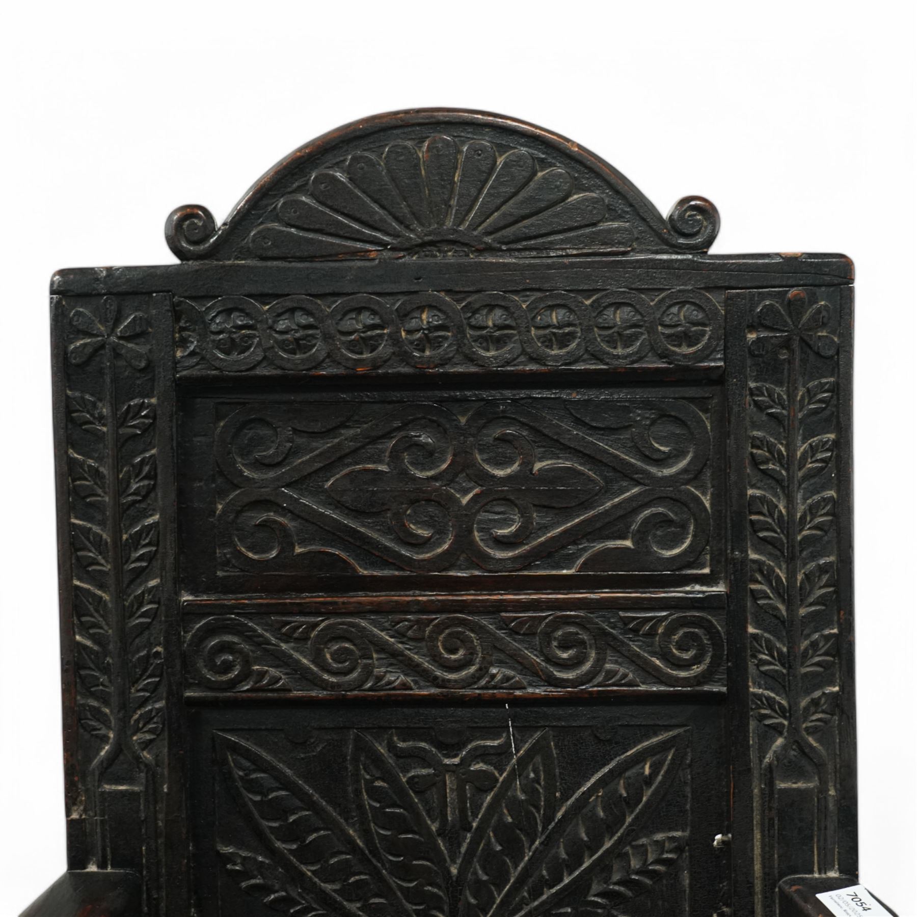 17th century and later carved oak Wainscot chair, the panelled back decorated with carved foliage and scrolls, the frame decorated with trailing guilloche and foliate motifs, moulded seat over turned supports united by stretchers 