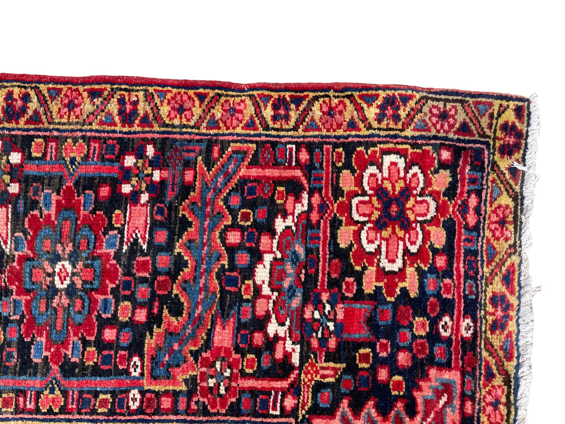 Antique Persian coral ground carpet, the large central floral pole medallion with extending foliate designs, the thick guarded indigo border with repeating flower heads and circles