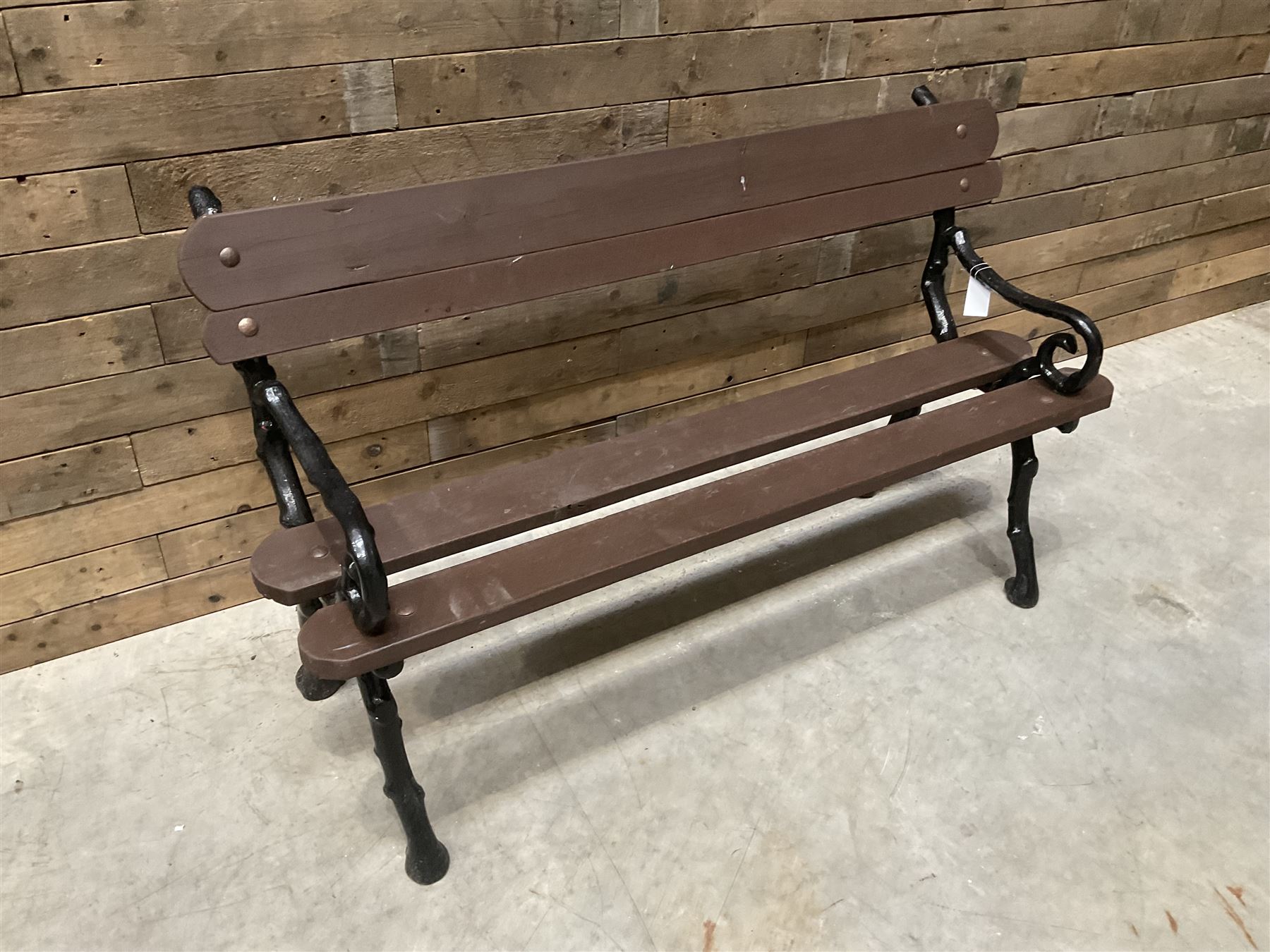 20th century tree cast iron and timber slatted garden bench, black painted frame with stained wood