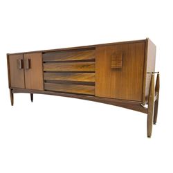 Elliots of Newbury (EoN) - mid-20th century teak sideboard, fitted with four central doors flanked by fall-front cupboard and a double cupboard, each with concave wooden handles