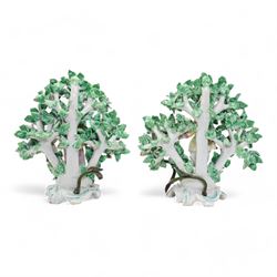 Pair of Bow porcelain 'New Dancers' candlesticks, standing before flowering bocages, and wearing brightly coloured flowered clothes, each supporting to left and right a tôle peinte branch terminating in a leaf moulded nozzle, on scrolling footed bases, red anchor and blue/red dagger marks beneath, H19cm x W18cm (2)