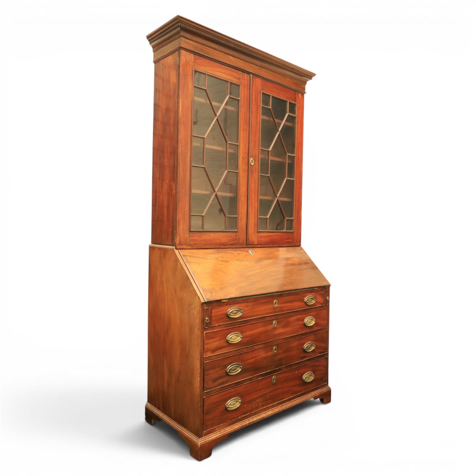 George III mahogany bureau bookcase, with projecting cornice top with dentil detail, astragal glazed cabinet enclosing fixed shelves, the lower section with fall front writing surface, fitted interior above four graduated drawers, raised on bracket feet