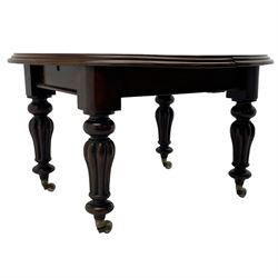 Victorian mahogany extending dining table, circular telescopic extending top with moulded edge, two additional leaves, on turned and lobe carved supports with brass and ceramic castors 
